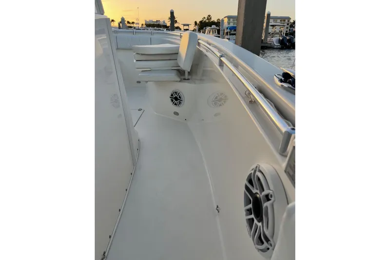 Slide: The Image of 2020 Cobia 262 Center Console boat interior with seating and speakers at sunset. - 16