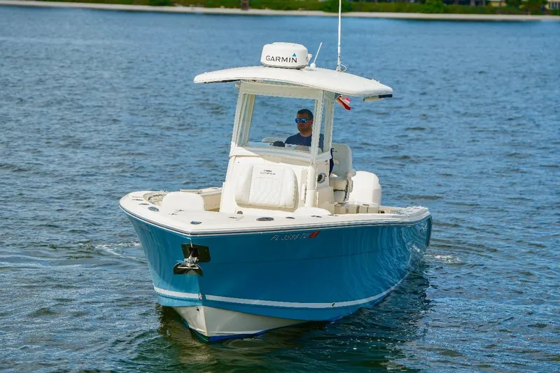 Slide: The Image of 2020 Cobia 262 Center Console boat cruising on water with a person at the helm. - 3