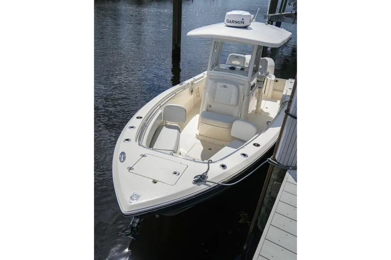 Slide: The Image of 2020 Cobia 262 Center Console boat docked on calm water. - 4
