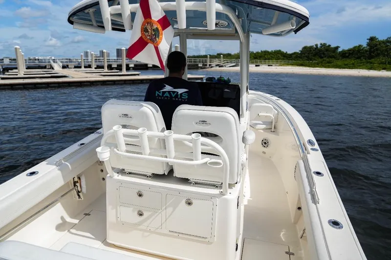 Slide: The Image of 2020 Cobia 262 Center Console boat on water, featuring spacious deck and Florida flag. - 9