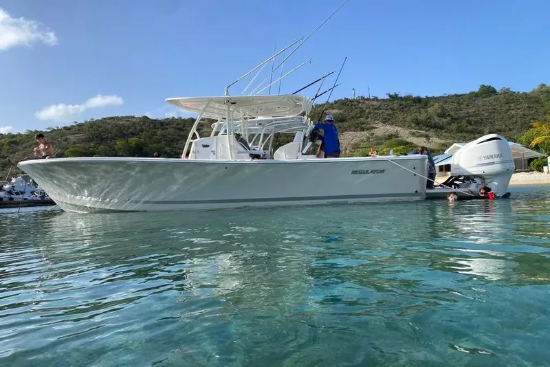 The Image of 2016 Regulator 34 Center Console boat in clear water near a scenic shoreline. - 0