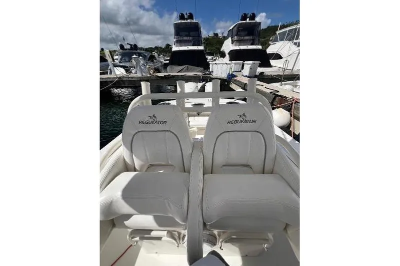 Slide: The Image of 2016 Regulator 34 Center Console boat with white seating at a marina. - 14