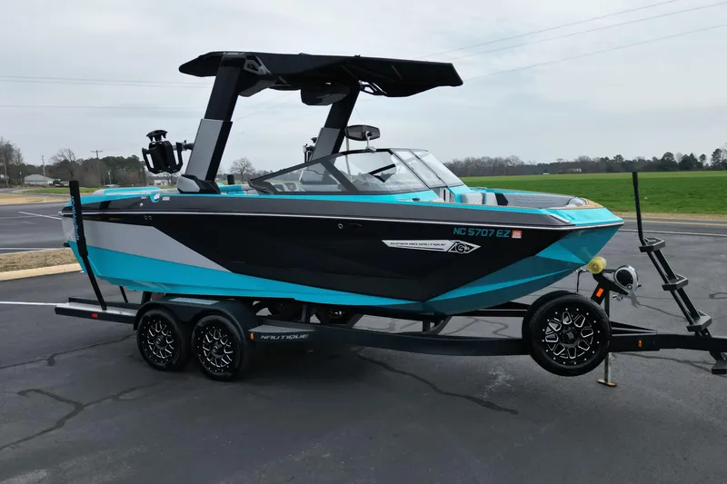 The Image of 2022 Nautique Super Air Nautique G21 boat on trailer, vibrant blue and black design. - 1