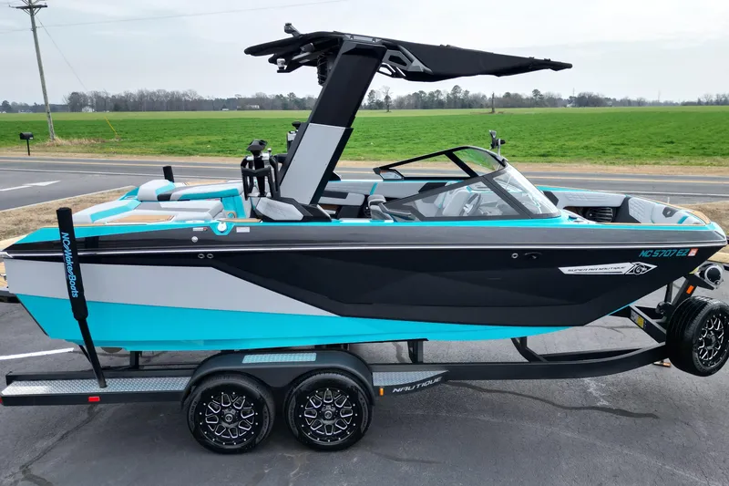Slide: The Image of 2022 Nautique Super Air Nautique G21 boat on trailer, vibrant blue and black design. - 20