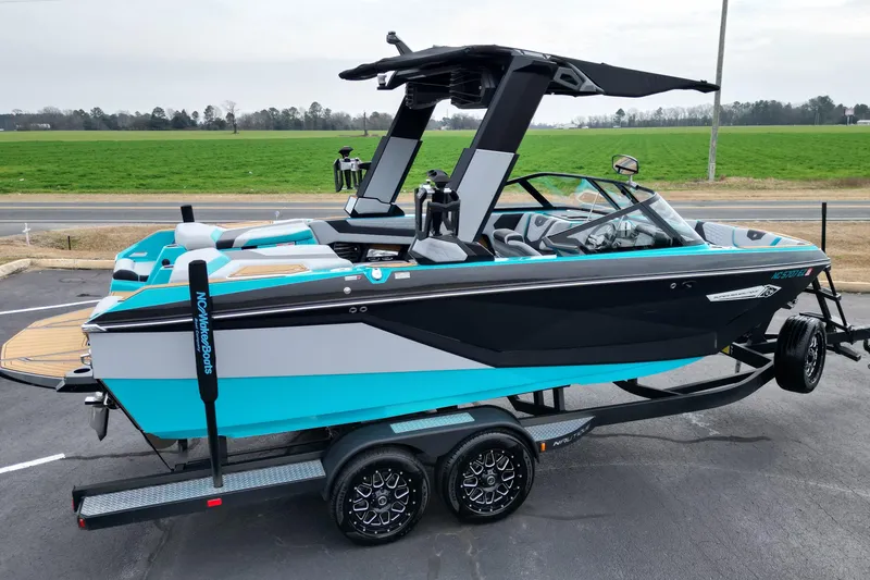 Slide: The Image of 2022 Nautique Super Air Nautique G21 boat on trailer, vibrant blue and black design. - 21