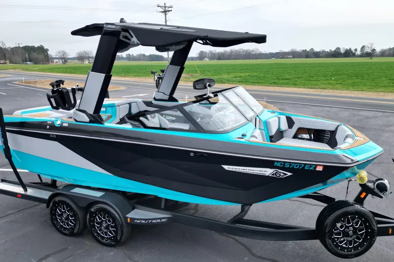 Slide: The Image of 2022 Nautique Super Air Nautique G21 boat on trailer, vibrant blue and black design. - 6