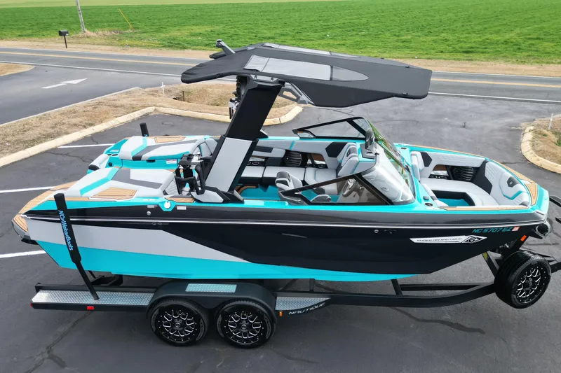 Slide: The Image of 2022 Nautique Super Air Nautique G21 boat on trailer, vibrant blue and black design. - 7
