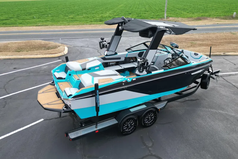 Slide: The Image of 2022 Nautique Super Air Nautique G21 boat on trailer, vibrant blue and black design. - 9