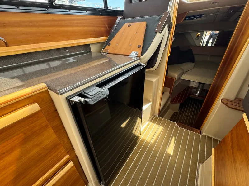 Slide: The Image of Interior of a 2015 Cutwater C-26 boat featuring a compact kitchen area. - 14