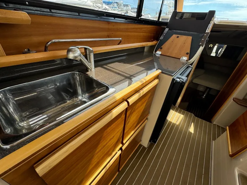 Slide: The Image of 2015 Cutwater C-26 boat interior with wooden cabinetry and stainless steel sink. - 15