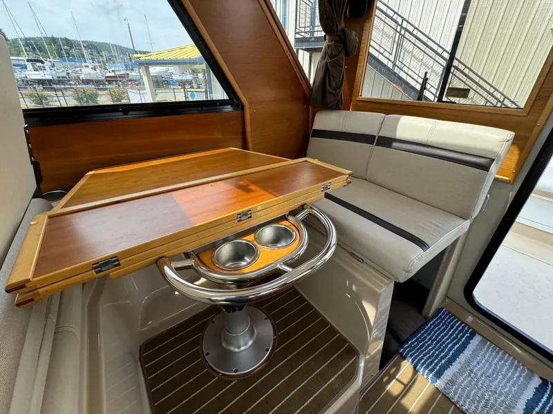 Slide: The Image of Interior of 2015 Cutwater C-26 boat with wooden table and cushioned seating. - 16