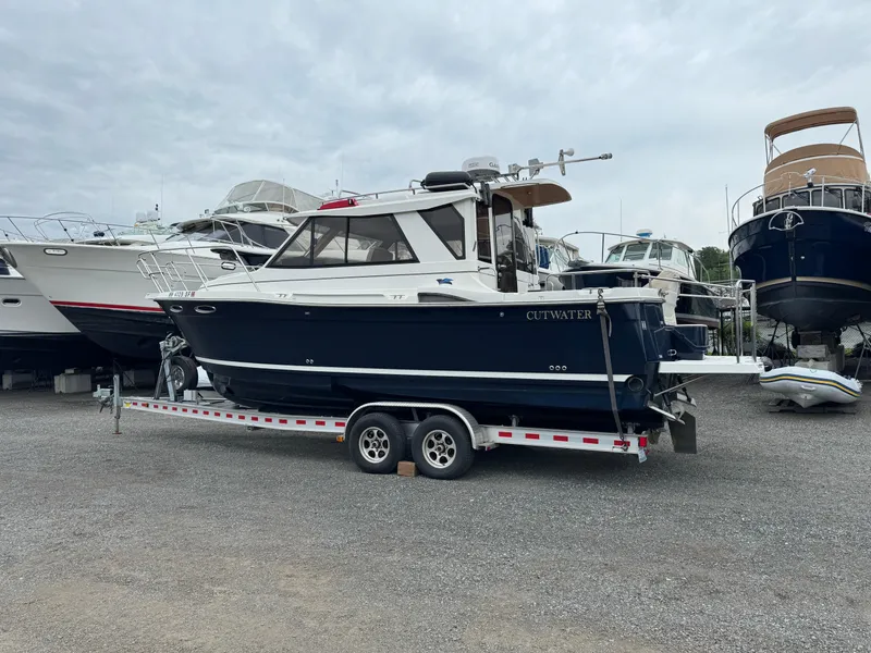 Slide: The Image of 2015 Cutwater C-26 boat on trailer in a marina, surrounded by other boats. - 2