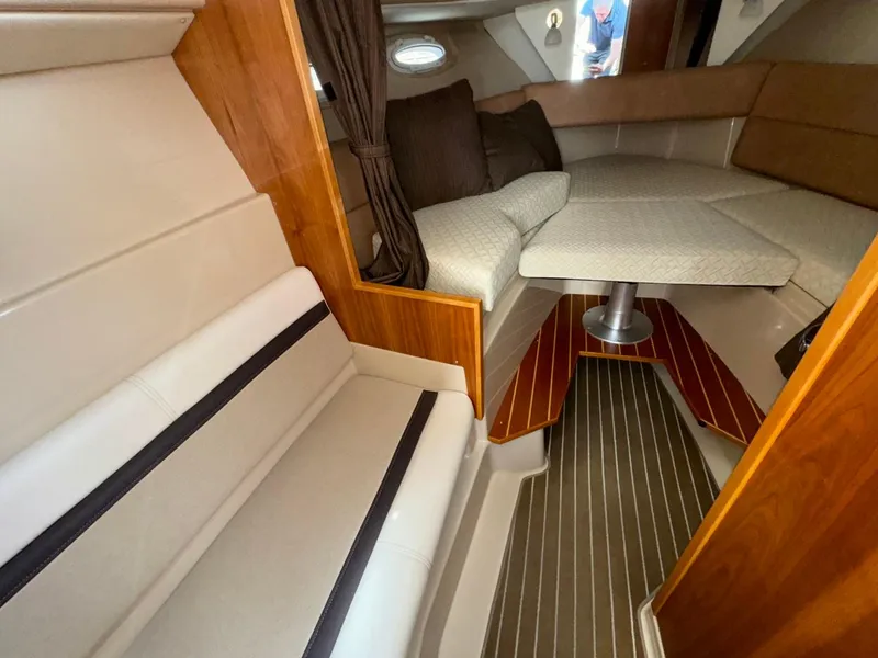 Slide: The Image of Interior of 2015 Cutwater C-26 boat with seating and table, featuring wood accents. - 20