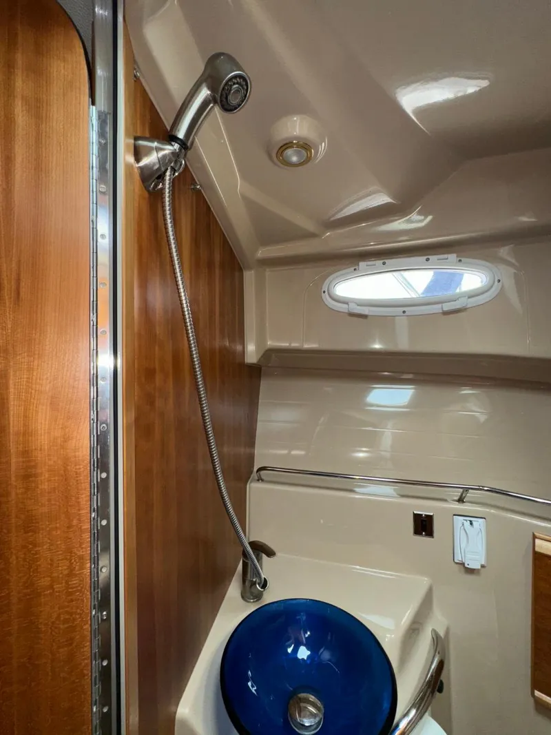 Slide: The Image of 2015 Cutwater C-26 bathroom with shower, blue sink, and wooden accents. - 23