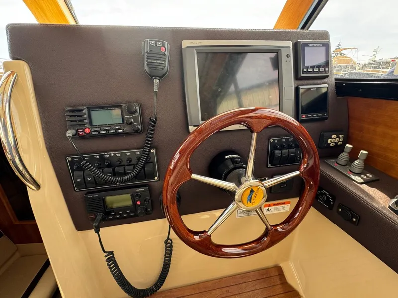 Slide: The Image of Helm of 2015 Cutwater C-26 boat with steering wheel, navigation controls, and communication devices. - 31