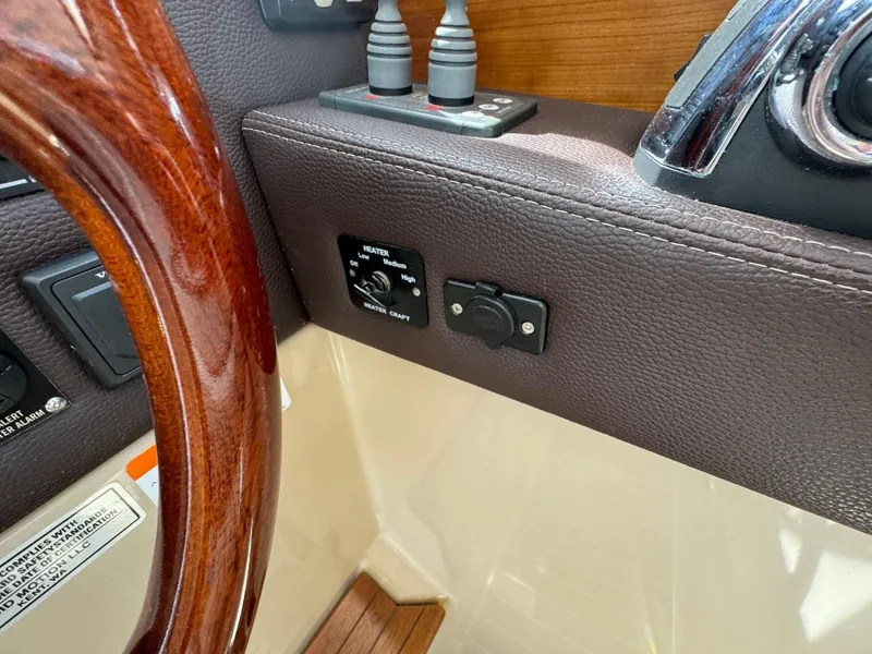 Slide: The Image of 2015 Cutwater C-26 boat dashboard with controls and wooden steering wheel. - 37