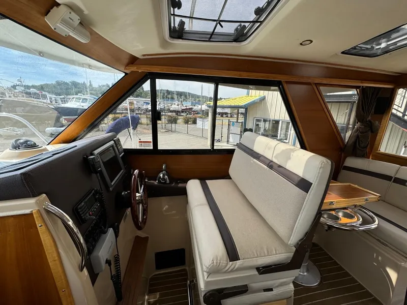 Slide: The Image of Interior of 2015 Cutwater C-26 boat with helm, seating, and large windows. - 40