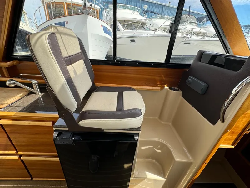Slide: The Image of Interior of 2015 Cutwater C-26 boat with cushioned seating and window view of marina. - 41