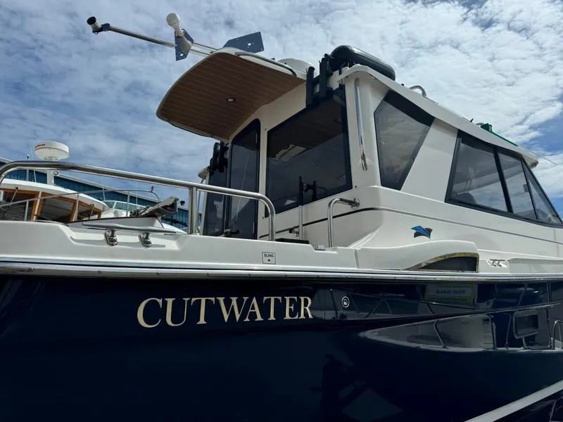 Slide: The Image of 2015 Cutwater C-26 boat with sleek design, docked under a partly cloudy sky. - 5