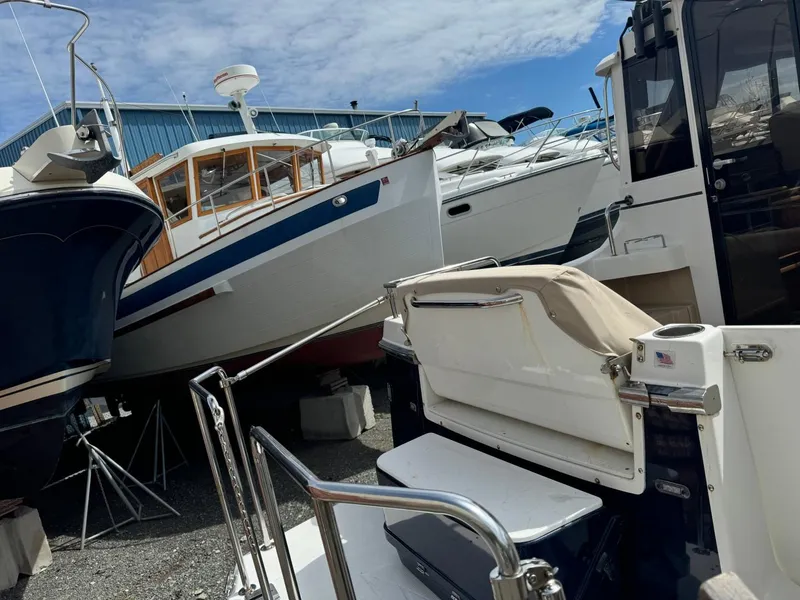 Slide: The Image of 2015 Cutwater C-26 boat in storage, surrounded by other vessels under a partly cloudy sky. - 6