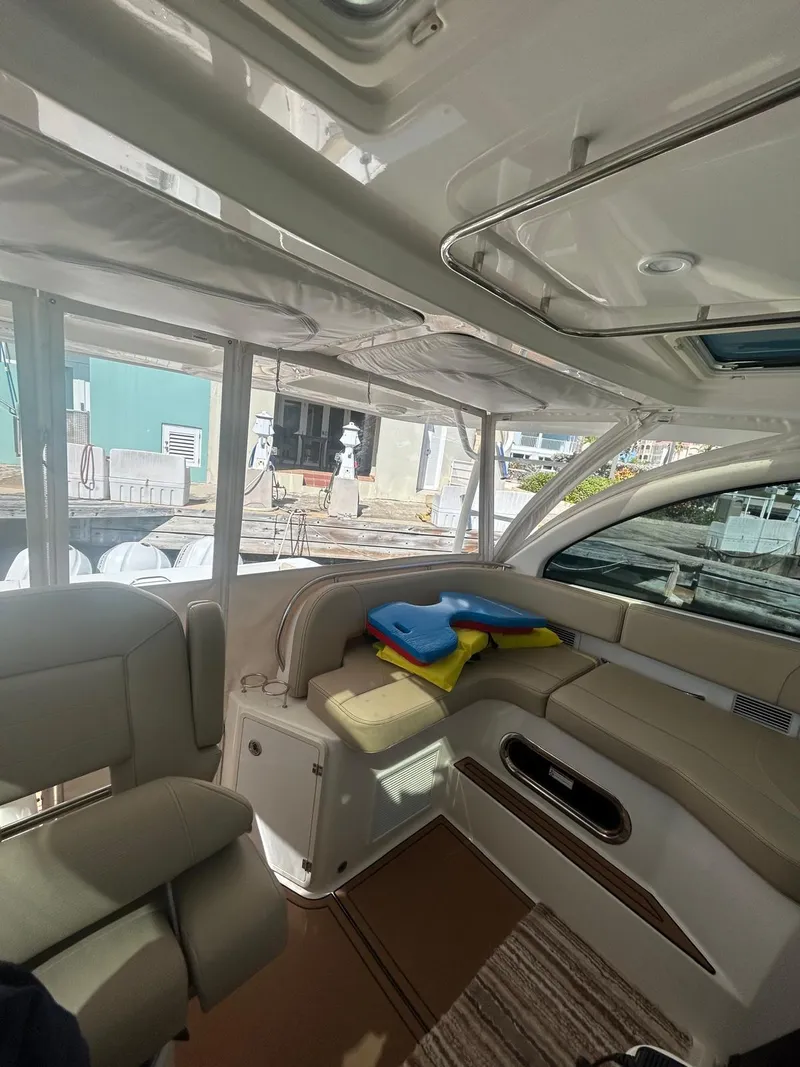 Slide: The Image of 2019 Pursuit OS 385 Offshore interior with beige seating and colorful life jackets. - 19