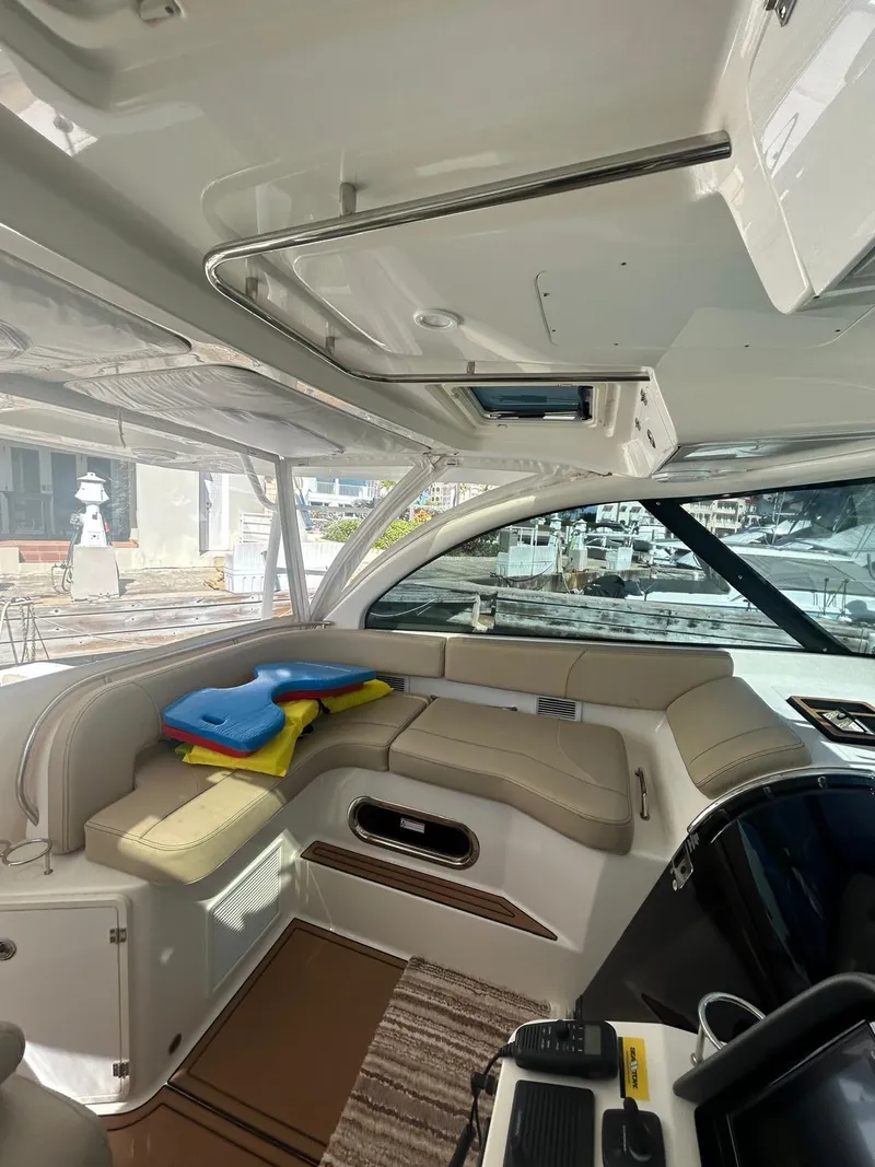 Slide: The Image of 2019 Pursuit OS 385 Offshore boat interior with beige seating and colorful cushions. - 20