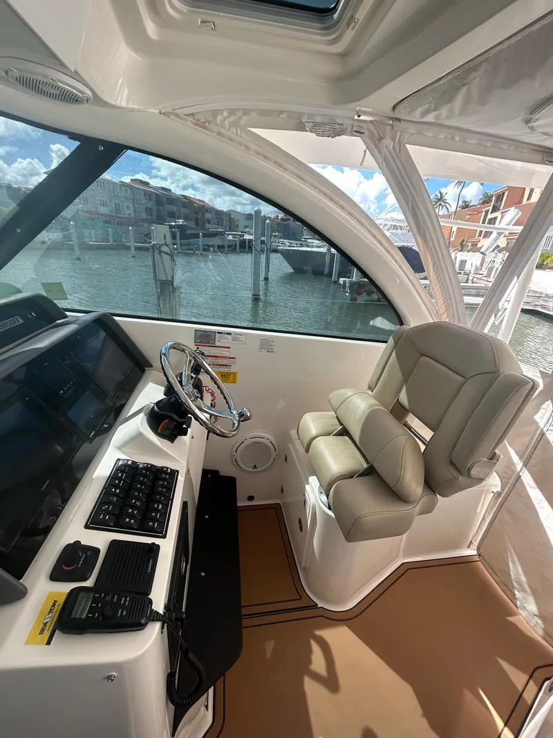 Slide: The Image of 2019 Pursuit OS 385 Offshore helm with leather seat and navigation controls. - 21