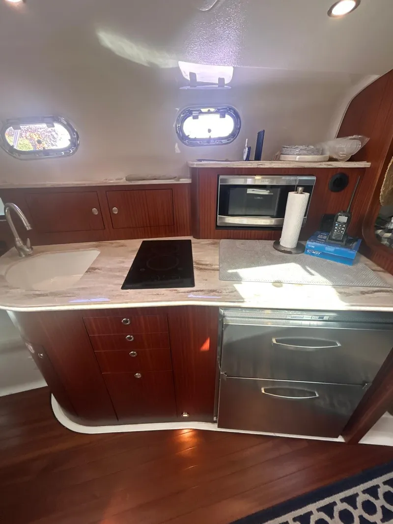 Slide: The Image of 2019 Pursuit OS 385 Offshore yacht kitchen with modern appliances and wooden cabinetry. - 24