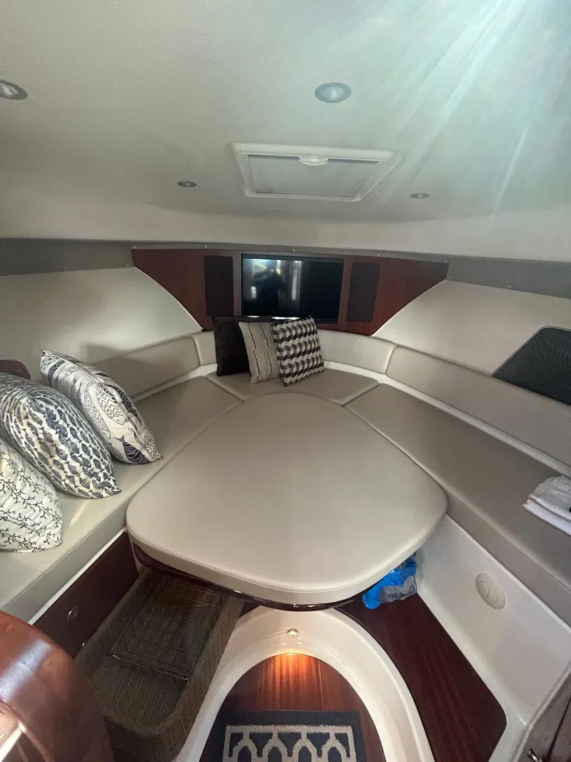 Slide: The Image of 2019 Pursuit OS 385 Offshore cabin interior with plush seating and decorative pillows. - 26