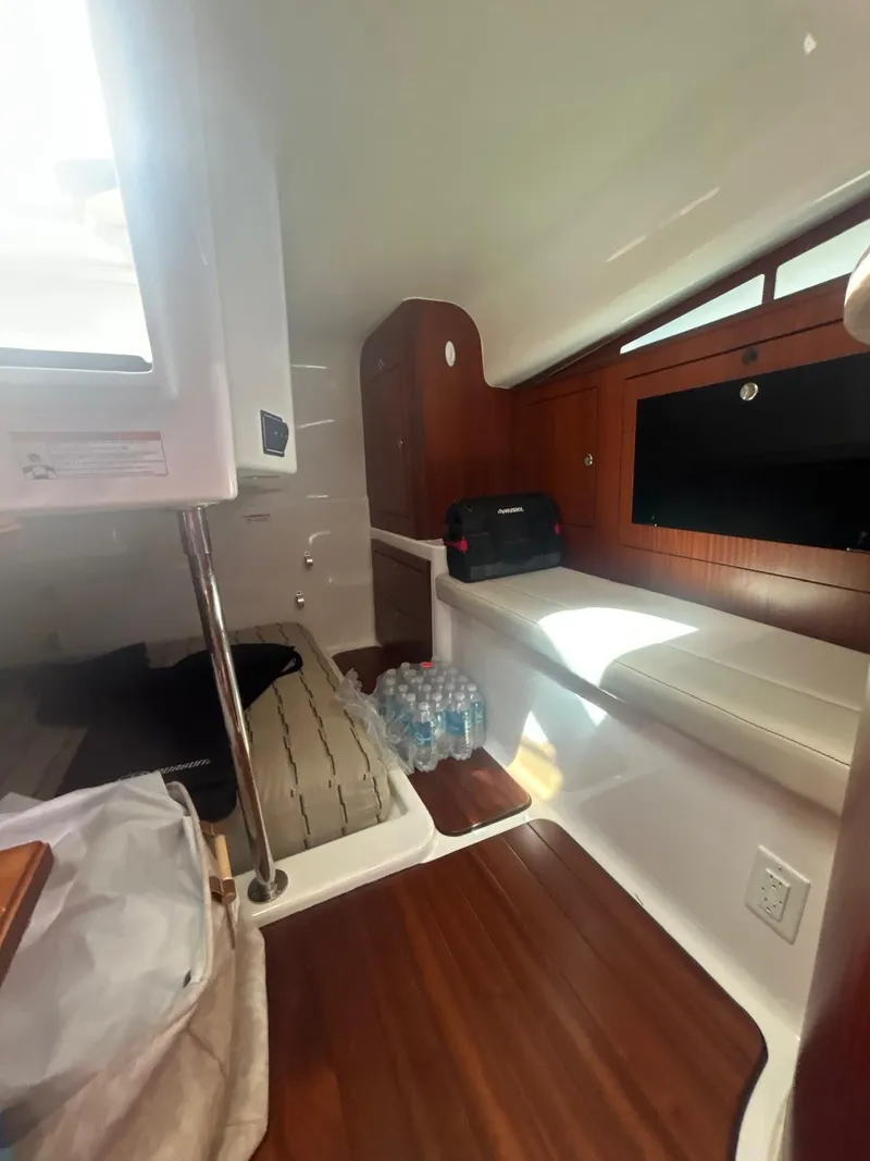Slide: The Image of 2019 Pursuit OS 385 Offshore cabin interior with seating, wooden flooring, and storage. - 27