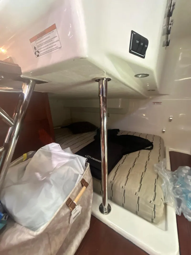 Slide: The Image of 2019 Pursuit OS 385 Offshore cabin interior with bed and storage area. - 28