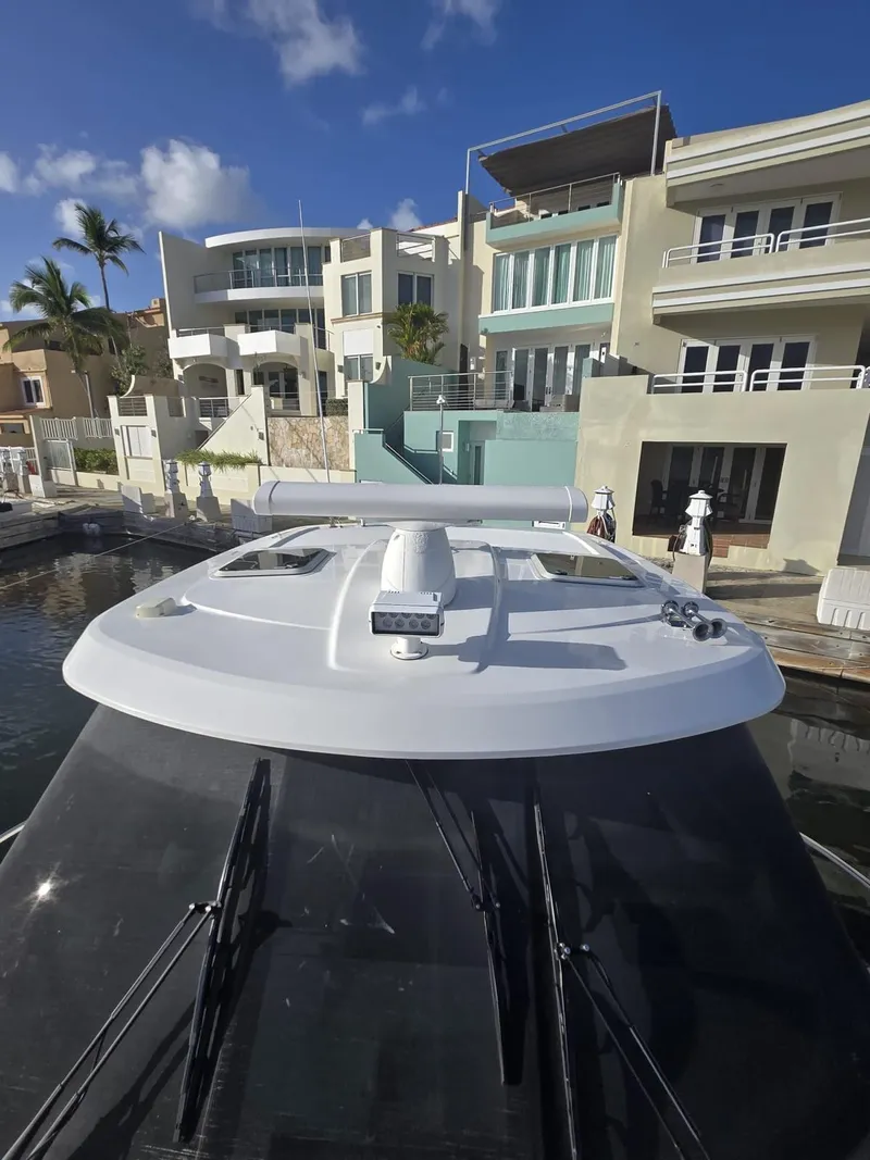 Slide: The Image of 2019 Pursuit OS 385 Offshore yacht docked near modern waterfront homes. - 5