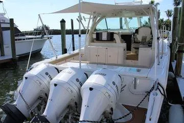 Slide: The Image of 2019 Pursuit OS 385 Offshore boat with triple Yamaha engines docked at marina. - 6