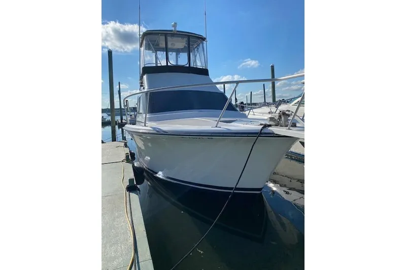Slide: The Image of 1990 Luhrs 320 Tournament boat docked under clear blue sky. - 10