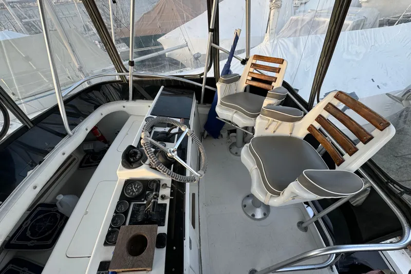 Slide: The Image of 1990 Luhrs 320 Tournament boat cockpit with steering wheel, gauges, and two cushioned chairs. - 11