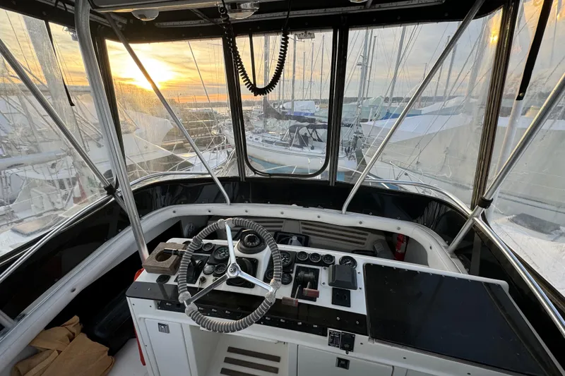 Slide: The Image of 1990 Luhrs 320 Tournament boat helm with steering wheel and controls at sunset. - 12