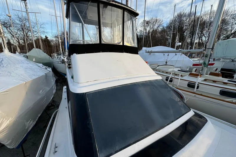 Slide: The Image of 1990 Luhrs 320 Tournament boat docked among other vessels, showcasing its cabin and deck. - 5