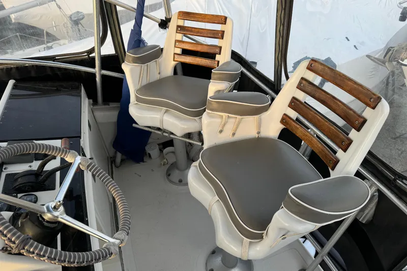 Slide: The Image of 1990 Luhrs 320 Tournament boat helm with dual captain chairs and steering wheel. - 6
