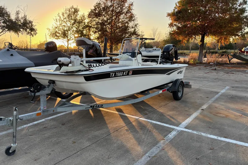 The Image of 2022 Mako Pro Skiff 17 CC boat on trailer at sunset in parking lot. - 0