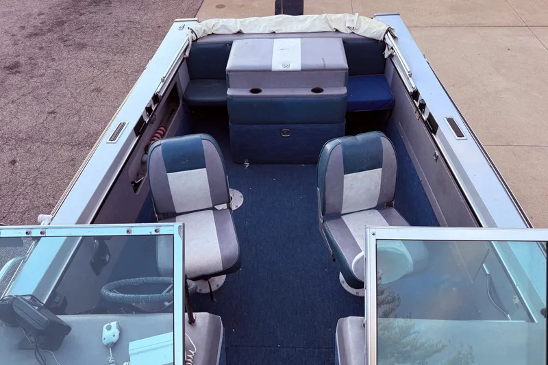 Slide: The Image of 1988 Lund boat interior with blue and gray seating, steering wheel, and dashboard. - 11