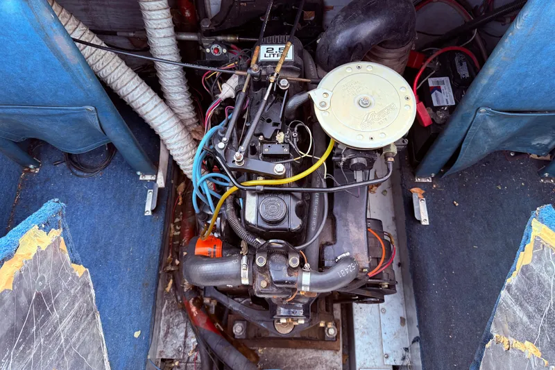 Slide: The Image of 1988 Lund boat engine with visible wiring and components, surrounded by blue interior. - 17