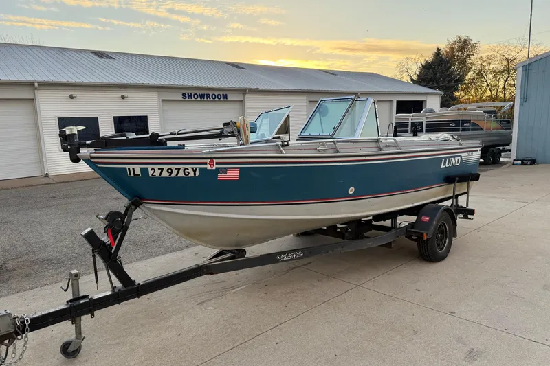 Slide: The Image of 1988 Lund boat on trailer outside showroom at sunset. - 3