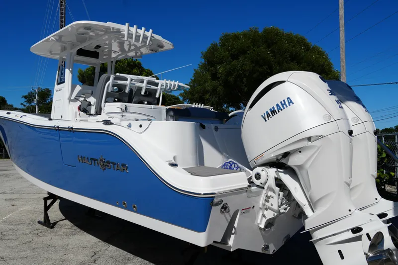 Slide: The Image of 2025 NauticStar 292 Legacy boat with Yamaha engines, blue and white design. - 2