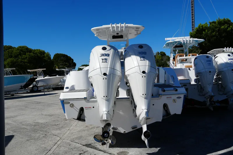 Slide: The Image of 2025 NauticStar 292 Legacy boat with dual 300 V6 engines, parked outdoors. - 3