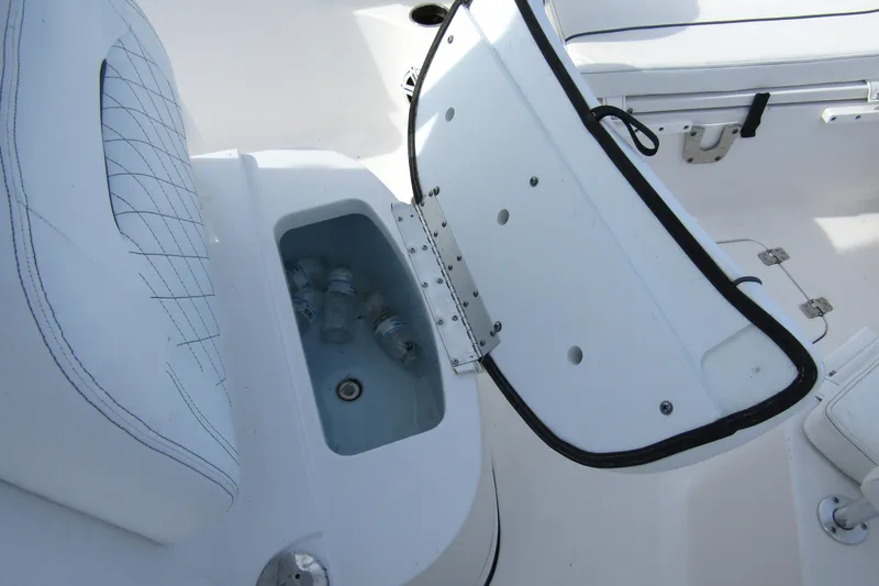 Slide: The Image of 2023 Sportsman Open 212 Center Console boat with open storage compartment and water bottles. - 15
