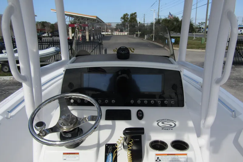 Slide: The Image of 2023 Sportsman Open 212 Center Console boat dashboard with steering wheel and controls. - 19