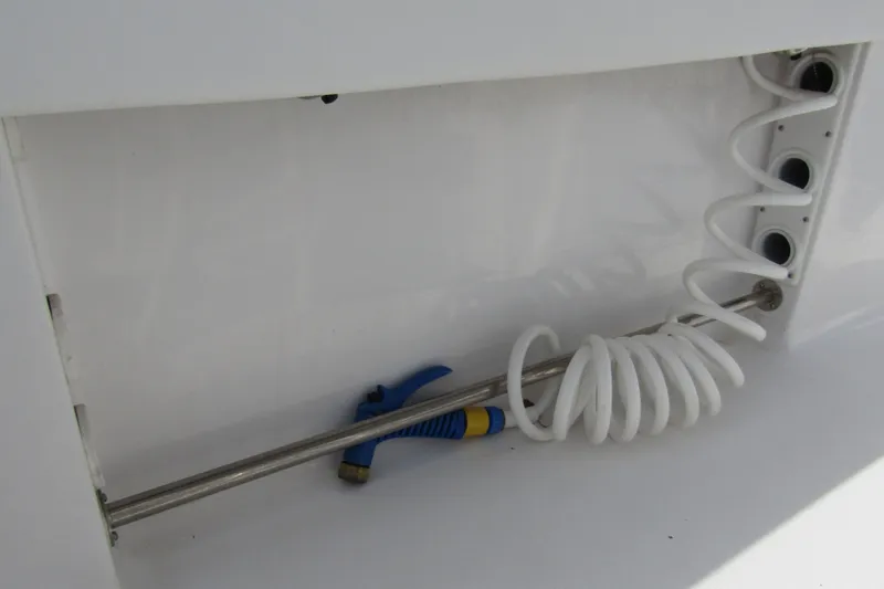 Slide: The Image of 2023 Sportsman Open 212 Center Console boat with coiled hose and storage compartment. - 27