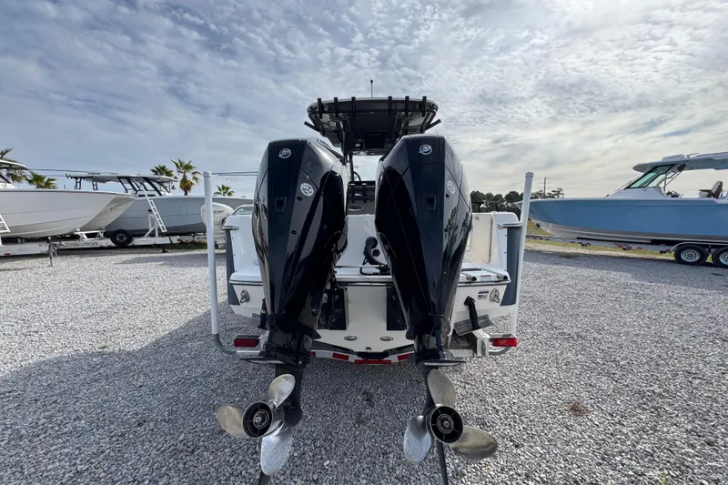 Slide: The Image of 2021 Sea Born LX26 Center Console with dual outboard motors on gravel lot. - 13
