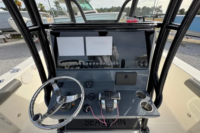 Slide: The Image of 2021 Sea Born LX26 Center Console dashboard with steering wheel and Simrad displays. - 32