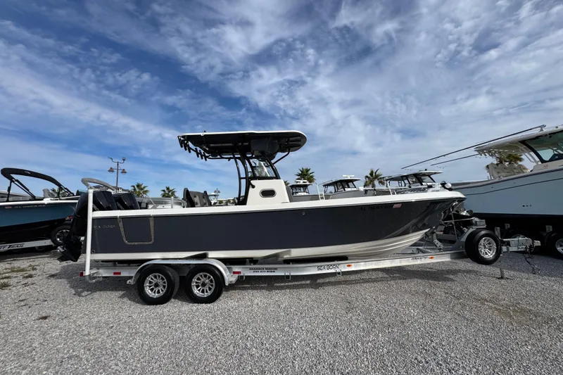 Slide: The Image of 2021 Sea Born LX26 Center Console boat on trailer under a cloudy sky. - 9